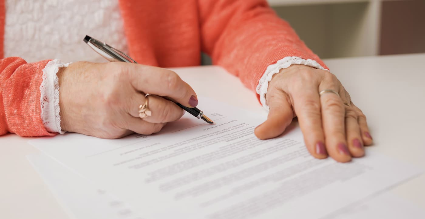 Personne âgée faisant un legs en signant son testament